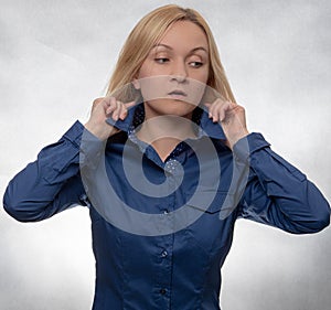 Curious young woman in casual blue shirt with hands in hair