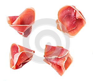 Curled Slices of Delicious Prosciutto isolated on white background top view