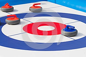 Curling stone placed in the center of a curling target or house, on a marked playing surface