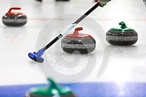 curling - stones and broom on the ice