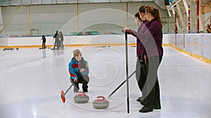 Curling training - the judge measuring the distance between two stones on the ice rink