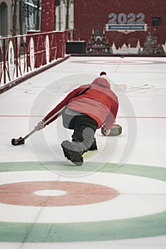 Curling training. Player plays curling on the ice rink, directing stone on target