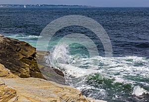 Curling wave hits ocean rocks