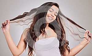 Curls, woman and hair strand with haircare in studio for salon treatment, hairstyle or shampoo on white background