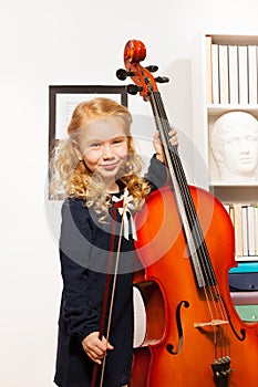 Curly beautiful girl with fiddlestick, violoncello photo