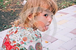 Curly blond child playing outdoors in summer.