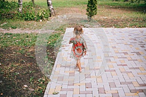 Curly blond child playing outdoors in summer.