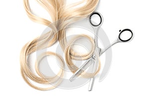 Curly blond hair and thinning scissors on white, top view. Hairdresser service