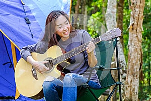 Curly blond long hair asian teenager girl with long shrit and white shorts playing guitar front