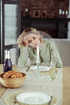 Curly blonde wife feeling melancholic staying alone at home