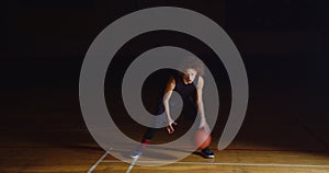 Curly Caucasian Basketball Player Dribbling Ball Camera Professional Darkness Ray Of Light