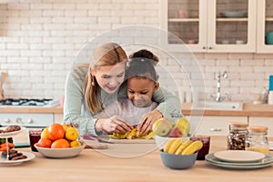 Curly daughter enjoying cooking with her foster mom