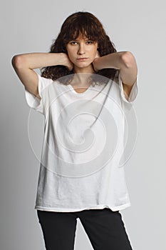 Curly fashion girl posing in white oversize t-shirt