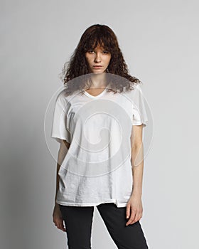 Curly fashion girl posing in white oversize t-shirt