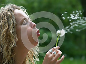 Curly girl blow dandelion