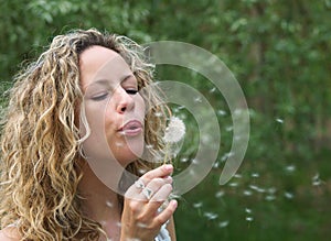 Curly girl blow dandelion