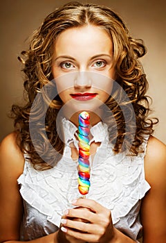 Curly girl with a lollipop in her hand