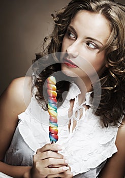 Curly girl with a lollipop in her hand