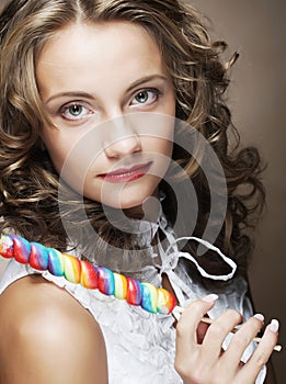 Curly girl with a lollipop in her hand