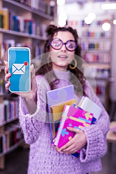 Curly good-looking young woman displaying unread message