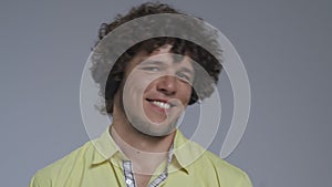 Curly guy hears the music and moves his head to the tact. Portrait of a dancing man. High quality
