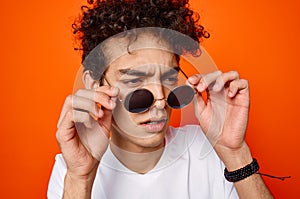 curly guy wearing sunglasses fashion youth style orange background