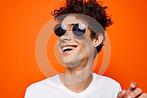 curly guy wearing sunglasses fashion youth style orange background