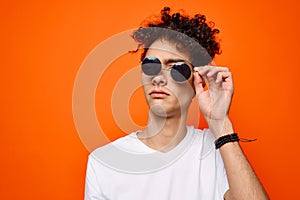 curly guy wearing sunglasses fashion youth style orange background