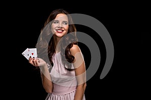 curly hair brunette posing with chips in her hands, poker concept black background