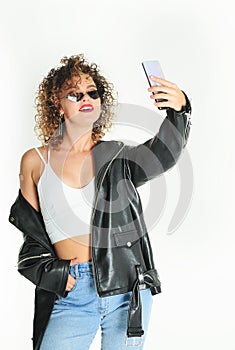Curly hair woman in sunglasses and leather jacket