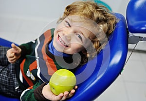 Curly-haired baby boy in dental chair