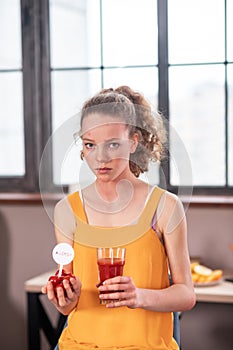 Curly-haired disquiet young lady having unusual food diet