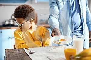 Curly-haired pre-teen boy refusing to eat fried egg