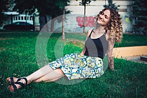 Curly-haired woman sitting on the grass