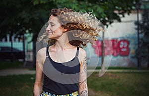 Curly haired woman with tattoos 