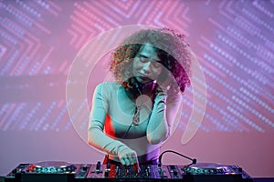 Curly haired young woman as female DJ