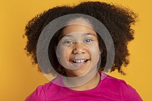 Curly Little Black Girl Smiling At Camera, Posing On Yellow Background