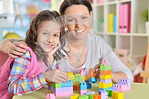 Curly little girl and her mother playing