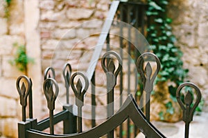 Curly metal prongs on a forged fence
