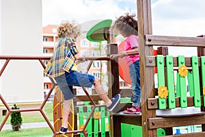 curly multiethnic little children climbing and having fun