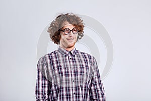 Curly nerd man in glasses with a stupid kind of funny emotion.