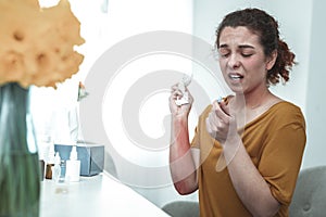 Curly red-haired woman with reddening on arm taking pill