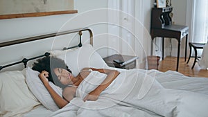 Curly woman sleeping bed at morning. Black skin lady napping home laying pillow