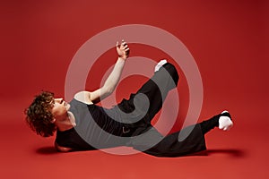 Curly young man expressing dynamic dance