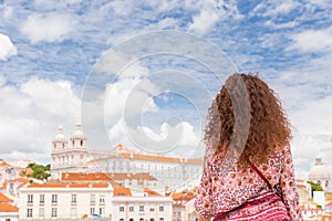 Curly young woman admiring the view from a miradouro in Lisbon P