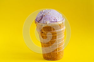 Currant ice cream in a waffle Cup on a yellow background