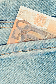 Currencies euro in back blue jeans pocket. Cash payment for shopping concept