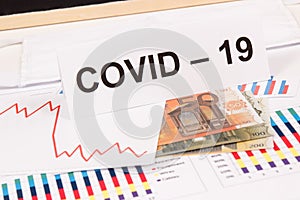 Currencies euro with downward graphs representing financial crisis caused by coronavirus. Covid-19