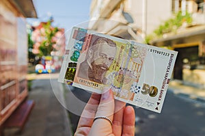 Currency - Bulgarian lev. A woman`s hand holds a 50 denomination bill on the street