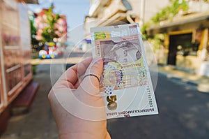 Currency - Bulgarian lev. A woman`s hand holds a 50 denomination bill on the street